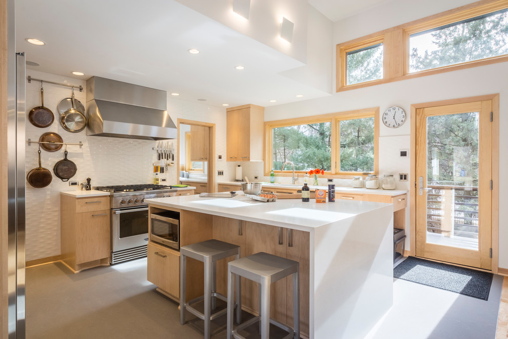 Example of a large trendy gray floor kitchen design in Minneapolis with flat-panel cabinets, quartz countertops, white backsplash, ceramic backsplash, stainless steel appliances, an island, white countertops and light wood cabinets