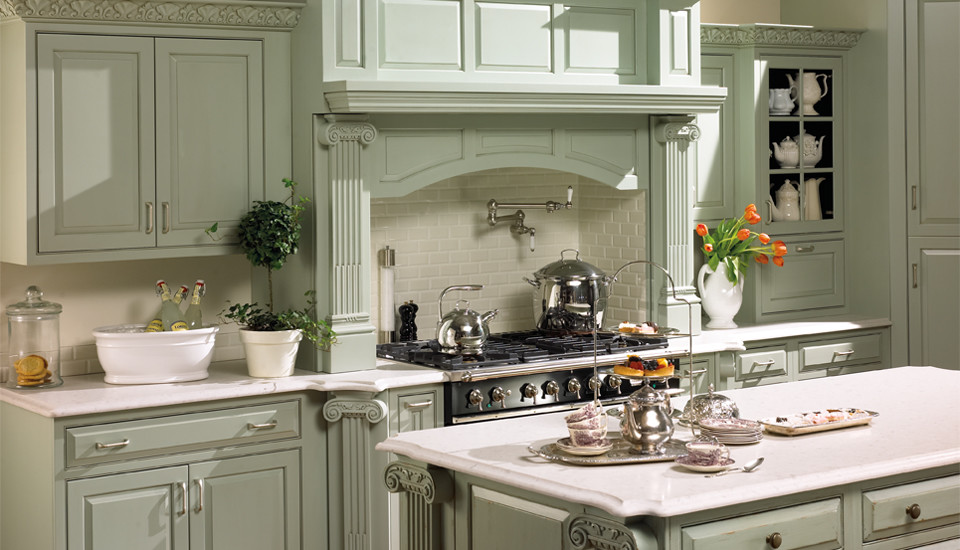 Inredning av ett klassiskt stort u-kök, med luckor med upphöjd panel, gröna skåp, bänkskiva i kalksten, vitt stänkskydd, stänkskydd i tunnelbanekakel, rostfria vitvaror och en köksö