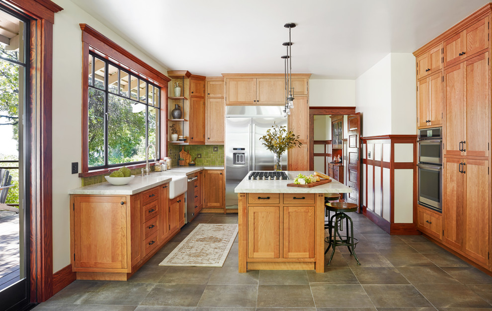 Urige Wohnküche in L-Form mit Landhausspüle, Schrankfronten im Shaker-Stil, hellbraunen Holzschränken, Küchenrückwand in Grün, Küchengeräten aus Edelstahl und Kücheninsel in Los Angeles