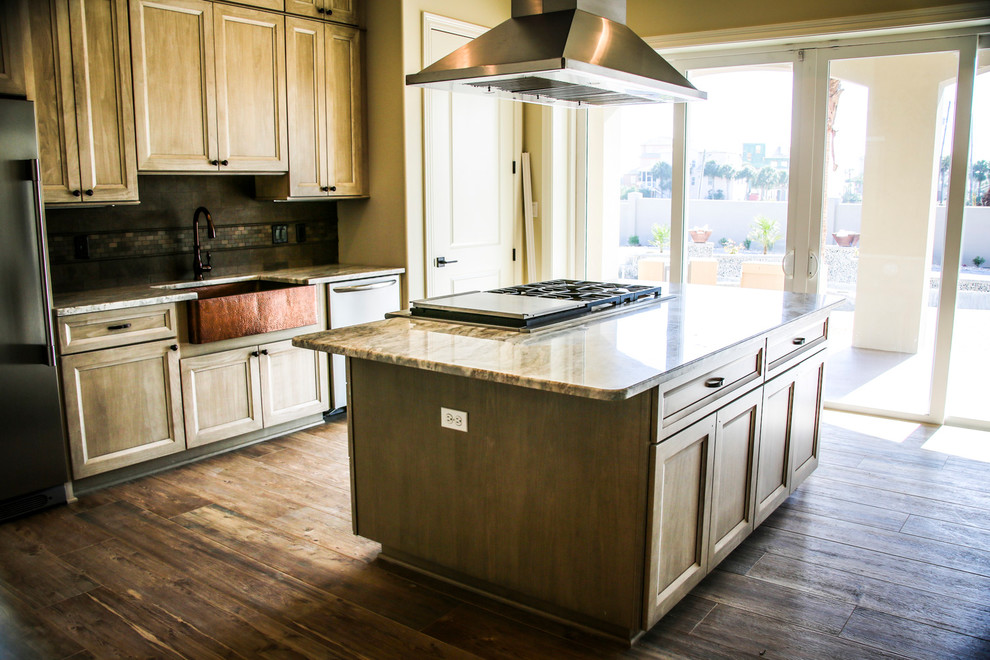 Modern inredning av ett avskilt flerfärgad linjärt flerfärgat kök, med en rustik diskho, luckor med infälld panel, beige skåp, granitbänkskiva, flerfärgad stänkskydd, stänkskydd i stenkakel, rostfria vitvaror, plywoodgolv, en köksö och brunt golv