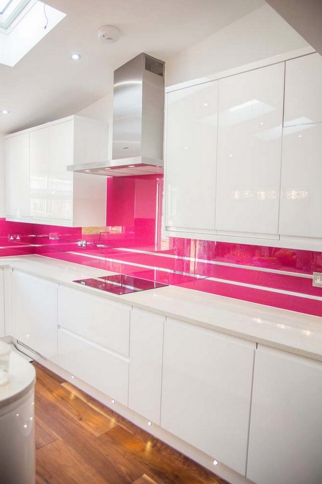 Modern kitchen in Hertfordshire with pink splashback and glass sheet splashback.