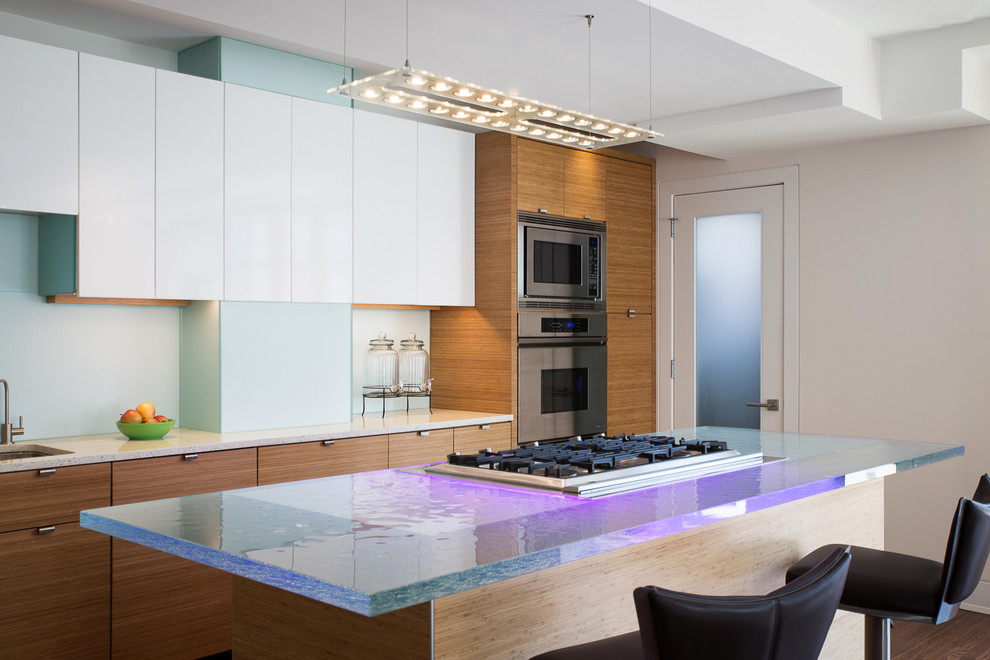 Foto de cocina contemporánea con armarios con paneles lisos, puertas de armario blancas, electrodomésticos de acero inoxidable, una isla y encimera de vidrio