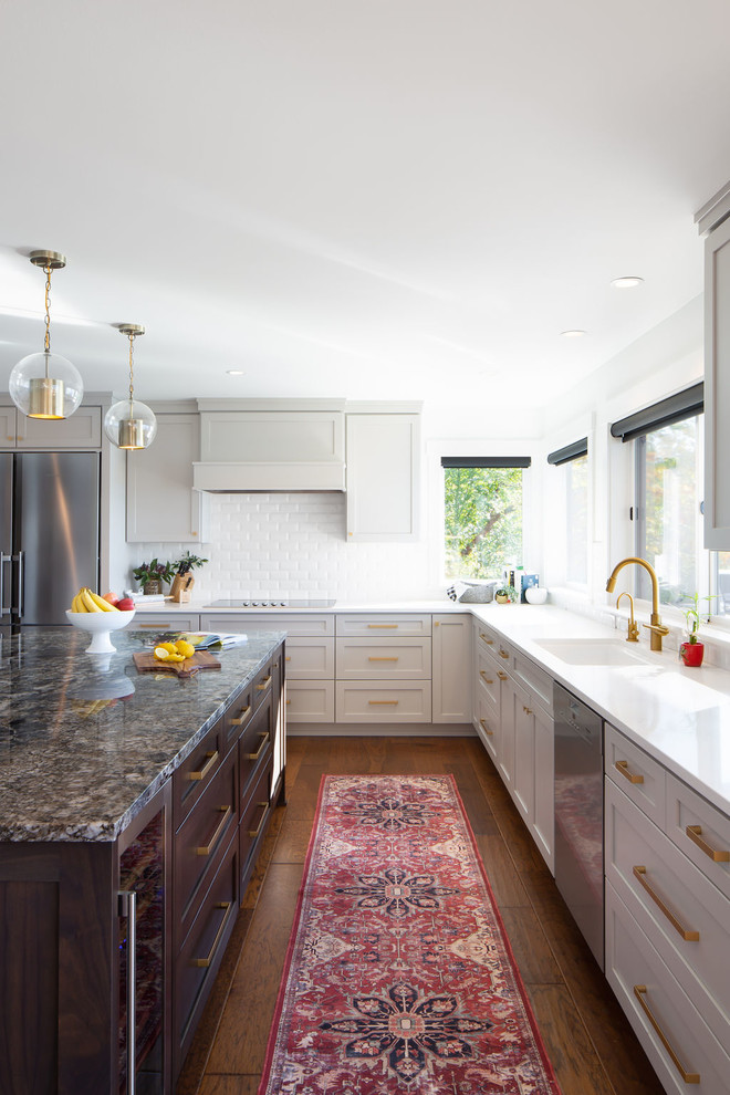 Eat-in kitchen - large transitional l-shaped dark wood floor and brown floor eat-in kitchen idea in Seattle with shaker cabinets, gray cabinets, granite countertops, white backsplash, subway tile backsplash, stainless steel appliances, an island and gray countertops