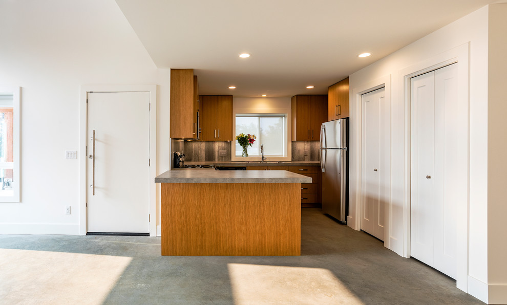Example of a small trendy u-shaped concrete floor and gray floor open concept kitchen design in Other with a double-bowl sink, flat-panel cabinets, light wood cabinets, laminate countertops, gray backsplash, cement tile backsplash, stainless steel appliances, a peninsula and gray countertops