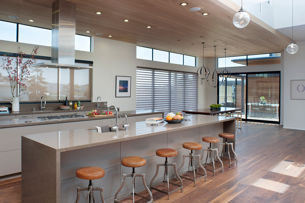 Immagine di un cucina con isola centrale design con ante lisce e ante grigie