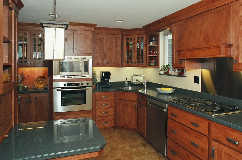 Small country galley cork floor enclosed kitchen photo in Other with an undermount sink, shaker cabinets, medium tone wood cabinets, solid surface countertops, blue backsplash and stainless steel appliances