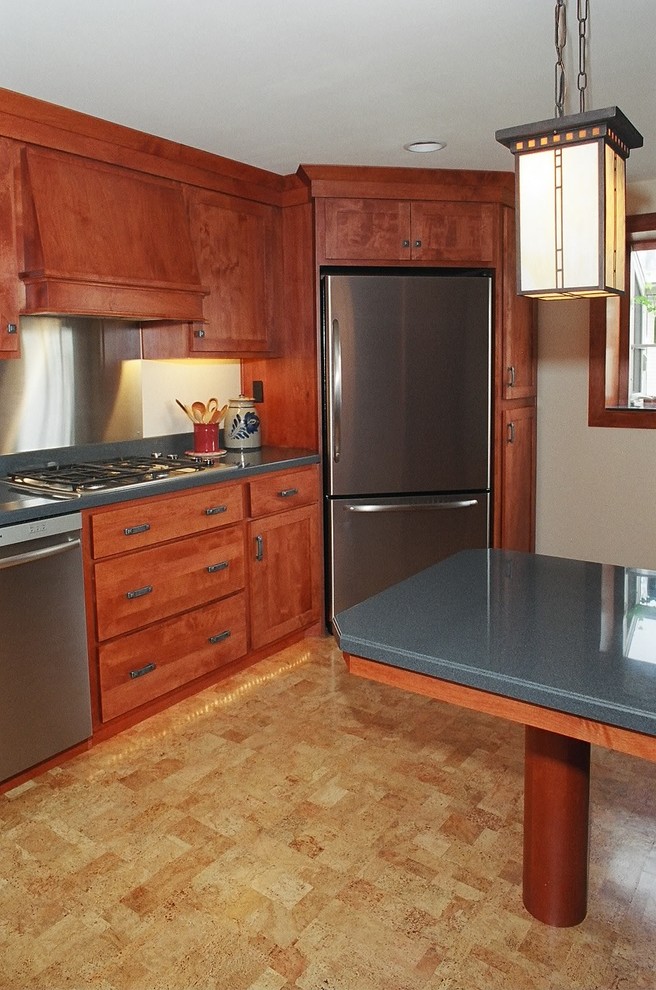 Aménagement d'une petite cuisine parallèle campagne en bois brun fermée avec un évier encastré, un placard à porte shaker, un plan de travail en surface solide, une crédence bleue, un électroménager en acier inoxydable et un sol en liège.