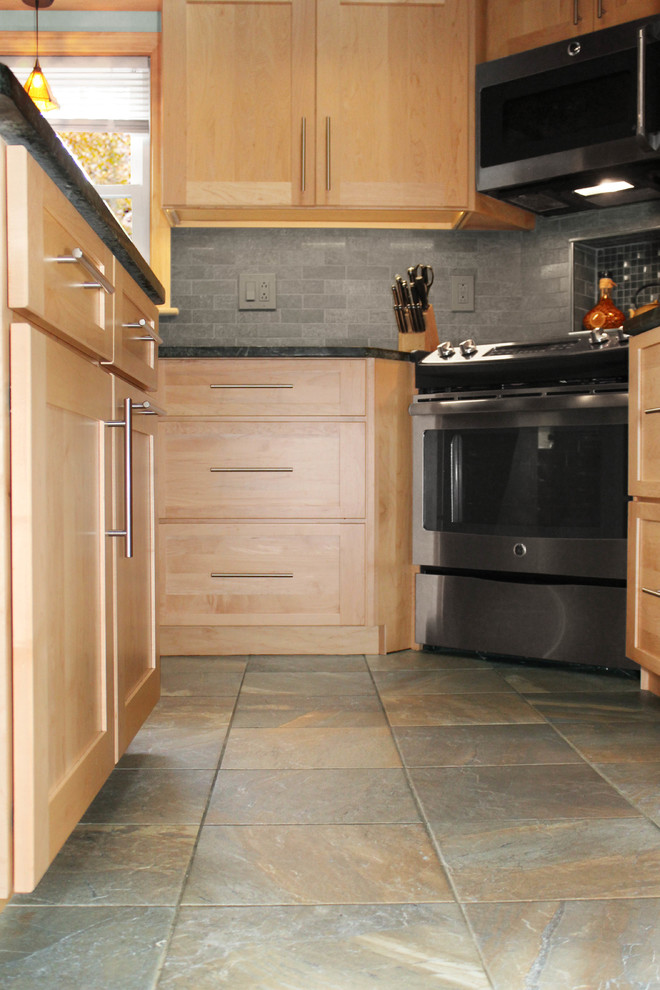 Idéer för att renovera ett litet vintage svart svart kök, med en undermonterad diskho, skåp i shakerstil, skåp i ljust trä, bänkskiva i täljsten, grått stänkskydd, stänkskydd i keramik, rostfria vitvaror, klinkergolv i porslin, en köksö och flerfärgat golv