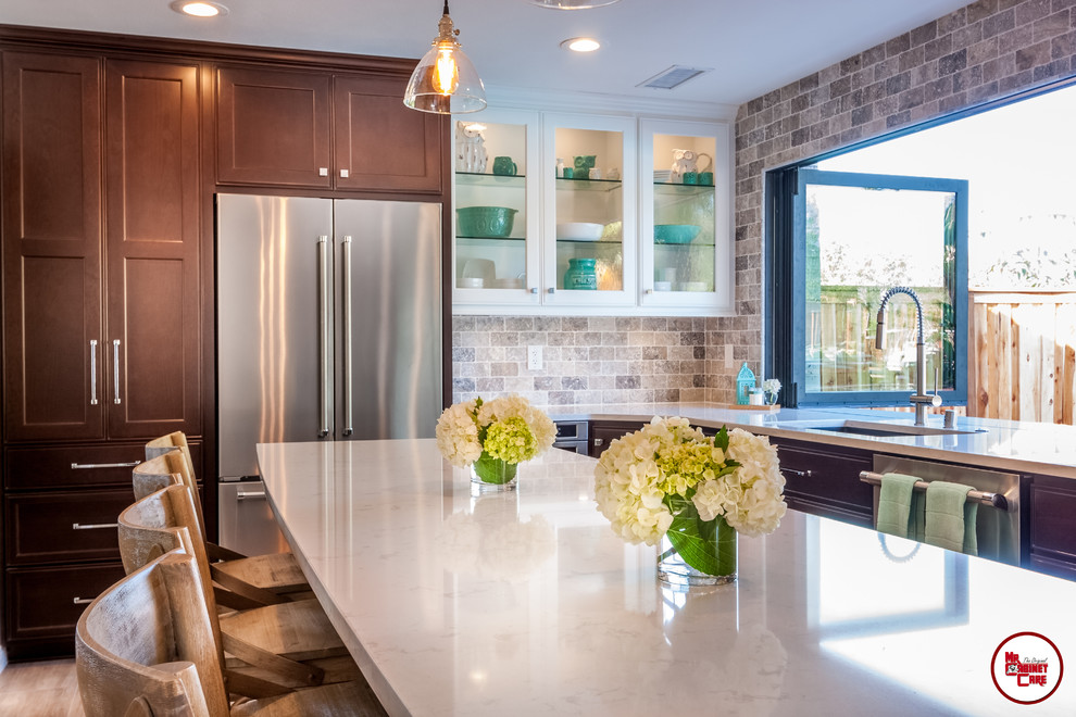 Inspiration for a classic kitchen/diner in Orange County with engineered stone countertops, stainless steel appliances, light hardwood flooring and an island.