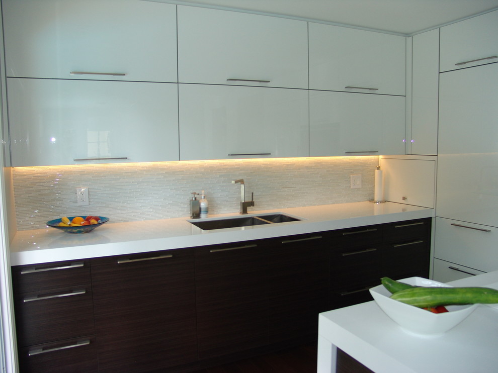 Mid-sized trendy l-shaped medium tone wood floor eat-in kitchen photo in Toronto with an undermount sink, flat-panel cabinets, white cabinets, quartz countertops, white backsplash, stone tile backsplash, stainless steel appliances and an island