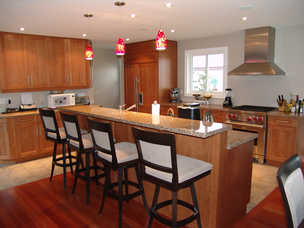 Medium sized contemporary l-shaped kitchen/diner in Toronto with a submerged sink, shaker cabinets, light wood cabinets, granite worktops, stainless steel appliances, travertine flooring and an island.