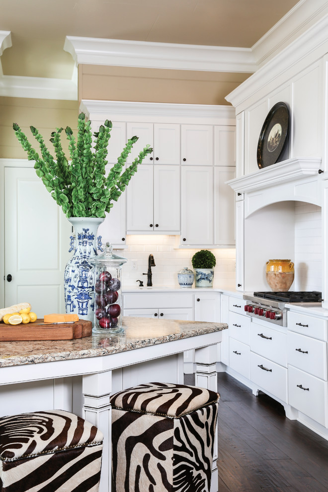 This is an example of a country kitchen in New Orleans with a submerged sink, shaker cabinets, white cabinets, engineered stone countertops, white splashback, metro tiled splashback, stainless steel appliances and an island.