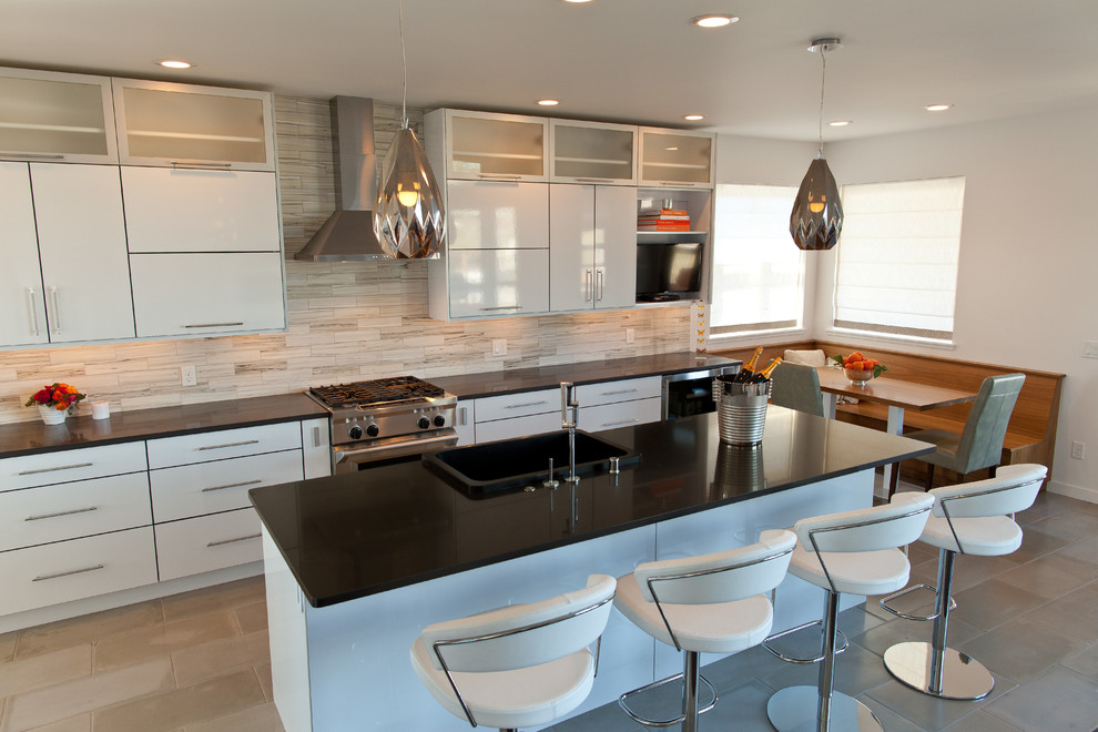 Modern inredning av ett kök med öppen planlösning, med en rustik diskho, vita skåp, bänkskiva i kvarts, rostfria vitvaror, betonggolv och en köksö