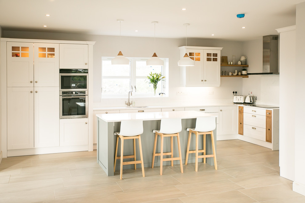 Immagine di una cucina nordica di medie dimensioni con ante bianche, top in quarzite, paraspruzzi bianco, elettrodomestici in acciaio inossidabile, ante in stile shaker e pavimento beige
