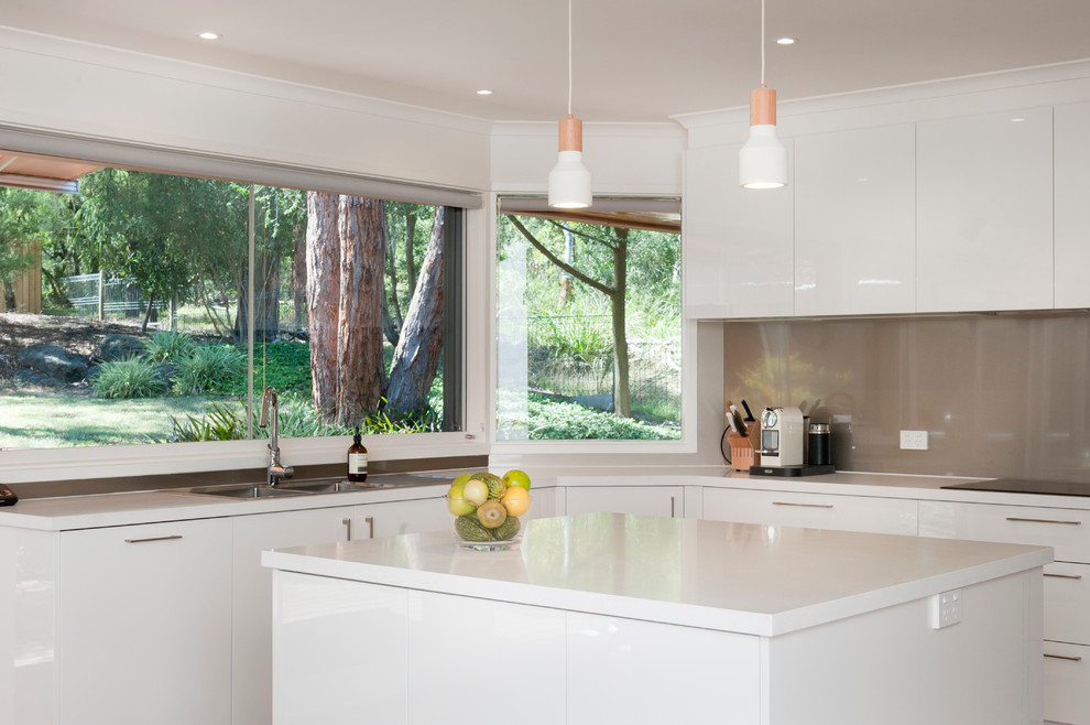 Mittelgroße Moderne Wohnküche in L-Form mit Doppelwaschbecken, weißen Schränken, Glas-Arbeitsplatte, Küchengeräten aus Edelstahl, hellem Holzboden und Kücheninsel in Melbourne