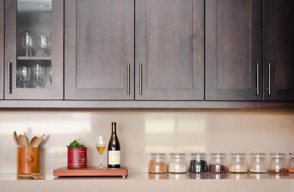 Open concept kitchen - large contemporary u-shaped medium tone wood floor and gray floor open concept kitchen idea in Los Angeles with a farmhouse sink, shaker cabinets, dark wood cabinets, quartz countertops, beige backsplash, stone slab backsplash, stainless steel appliances, an island and beige countertops