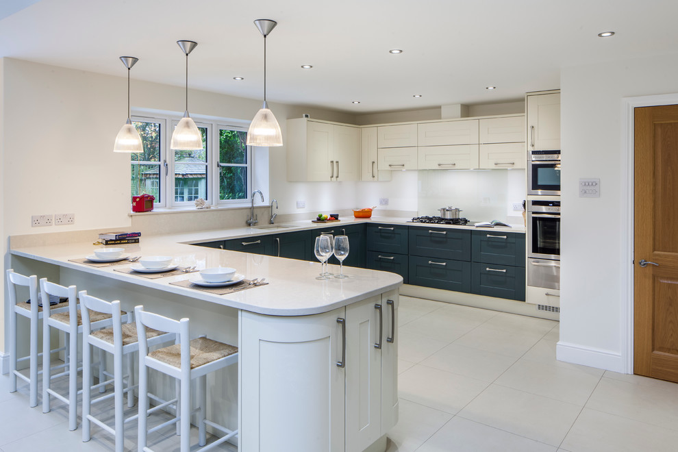 Große Klassische Wohnküche in U-Form mit Einbauwaschbecken, Schrankfronten im Shaker-Stil, Küchenrückwand in Metallic, Glasrückwand und Porzellan-Bodenfliesen in Hertfordshire