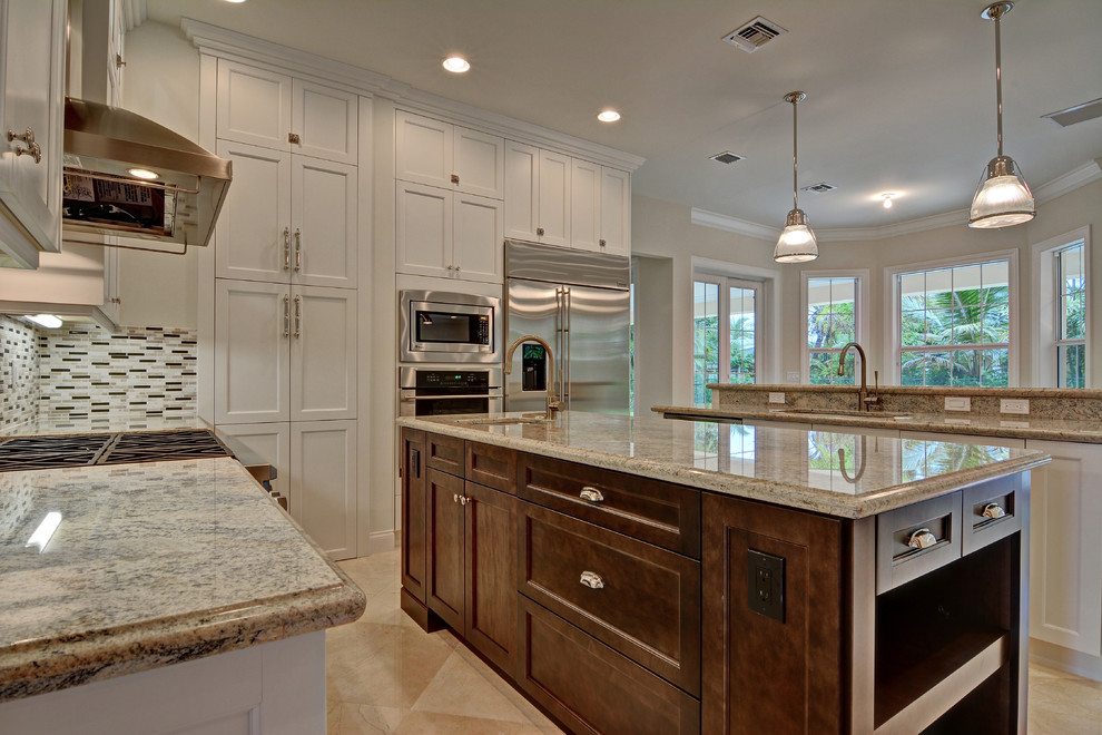 Eat-in kitchen - large traditional l-shaped marble floor eat-in kitchen idea in Miami with an undermount sink, recessed-panel cabinets, white cabinets, granite countertops, multicolored backsplash, mosaic tile backsplash, stainless steel appliances and two islands