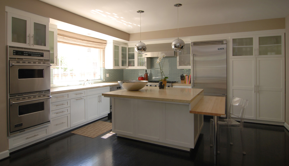 Пример оригинального дизайна: кухня в современном стиле с стеклянными фасадами, техникой из нержавеющей стали и барной стойкой