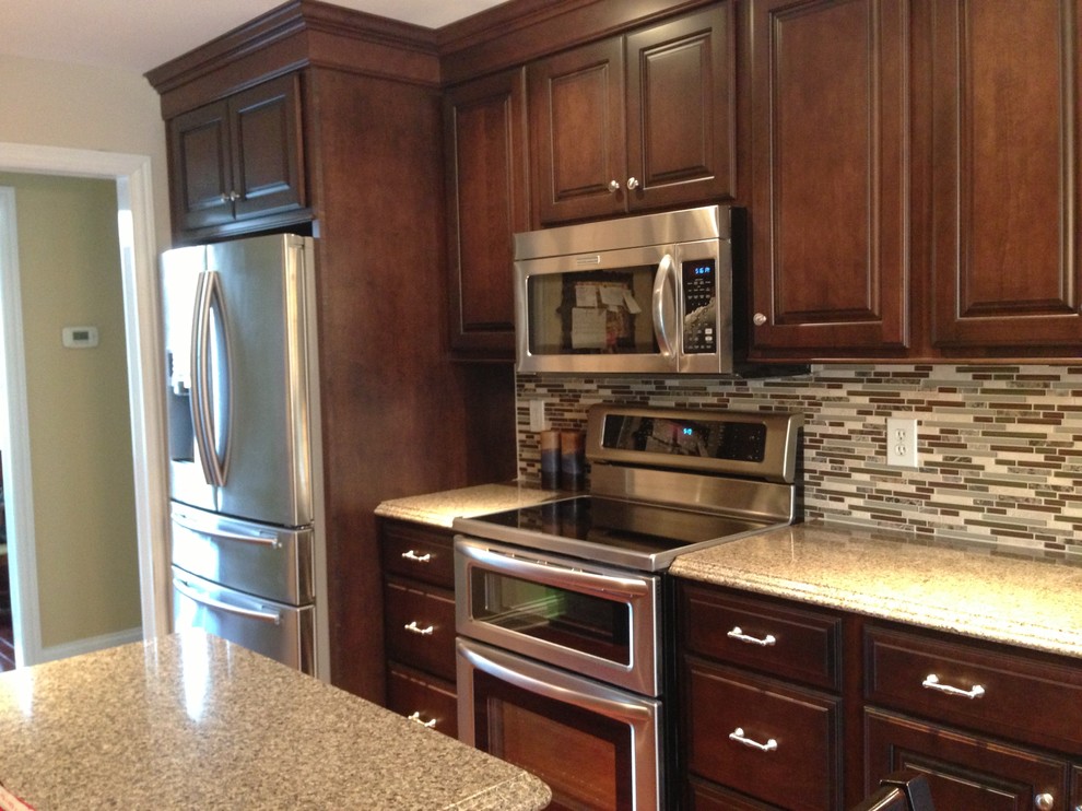 Inspiration for a transitional l-shaped eat-in kitchen remodel in Louisville with an undermount sink, raised-panel cabinets, dark wood cabinets, quartz countertops and stainless steel appliances