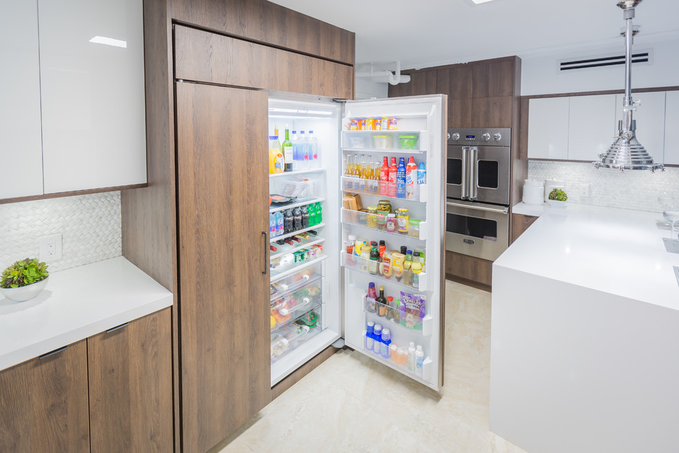 Small minimalist u-shaped enclosed kitchen photo in Miami with an undermount sink, flat-panel cabinets, medium tone wood cabinets, quartz countertops, white backsplash and stainless steel appliances