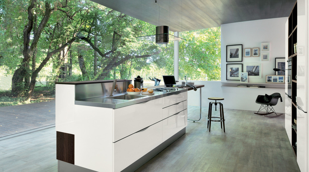 Bild på ett avskilt, stort funkis linjärt kök, med en integrerad diskho, skåp i shakerstil, vita skåp, bänkskiva i rostfritt stål, rostfria vitvaror, mörkt trägolv och en köksö
