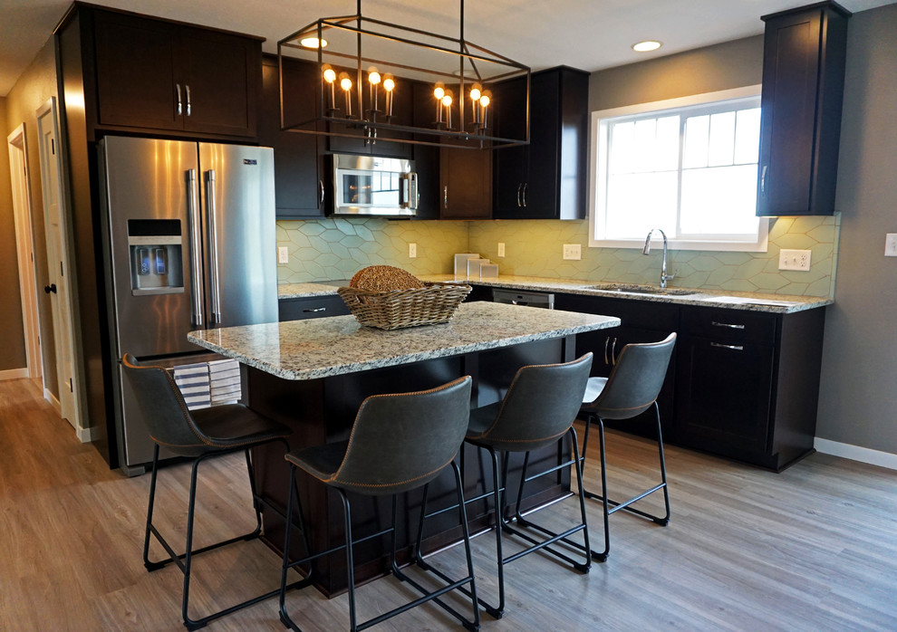 Bild på ett mellanstort funkis kök, med en undermonterad diskho, skåp i shakerstil, skåp i mörkt trä, granitbänkskiva, grönt stänkskydd, stänkskydd i terrakottakakel, rostfria vitvaror, vinylgolv, en köksö och grått golv