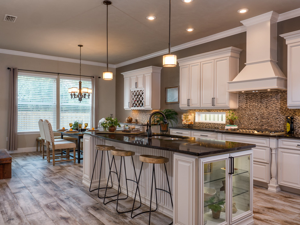 Example of a mid-sized arts and crafts u-shaped ceramic tile eat-in kitchen design in Miami with a double-bowl sink, beaded inset cabinets, white cabinets, quartzite countertops, metallic backsplash, stone tile backsplash, stainless steel appliances and an island