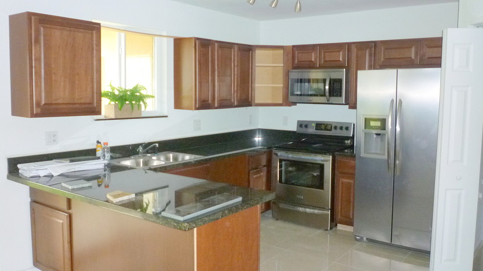Eklektische Küche mit Doppelwaschbecken, profilierten Schrankfronten, hellbraunen Holzschränken, Granit-Arbeitsplatte und Küchengeräten aus Edelstahl in Miami