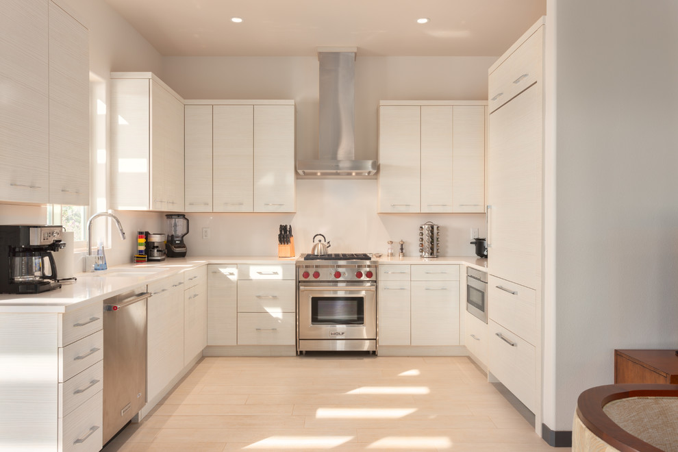Example of a mid-sized transitional u-shaped porcelain tile and beige floor enclosed kitchen design in Hawaii with flat-panel cabinets, white cabinets, quartz countertops, white backsplash, paneled appliances, no island and an undermount sink