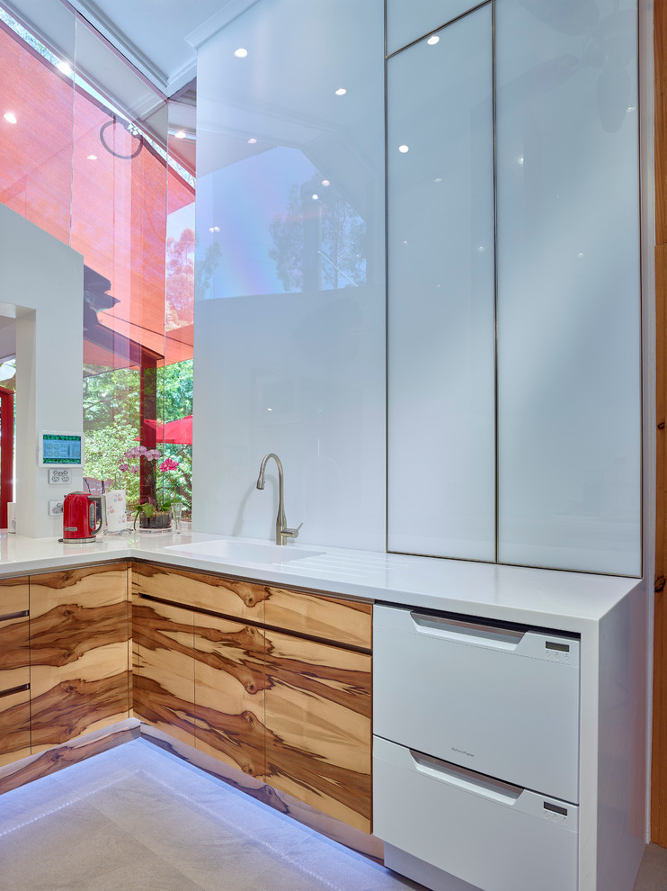 他の地域にあるラグジュアリーな広いコンテンポラリースタイルのおしゃれなキッチン (中間色木目調キャビネット、白いキッチンパネル、ガラス板のキッチンパネル、シルバーの調理設備) の写真