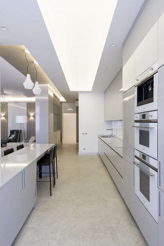 Imagen de cocina contemporánea extra grande abierta con armarios con paneles lisos, puertas de armario blancas, electrodomésticos blancos y península
