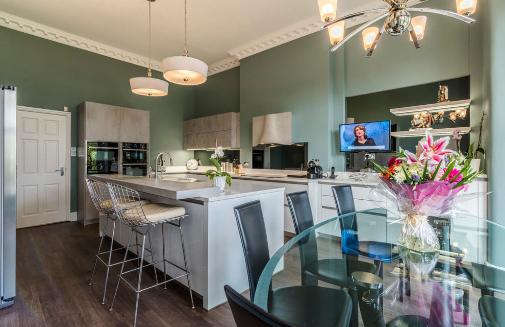 Photo of a large contemporary l-shaped kitchen/diner in Cheshire with flat-panel cabinets, white cabinets, dark hardwood flooring, an island, mirror splashback and brown floors.