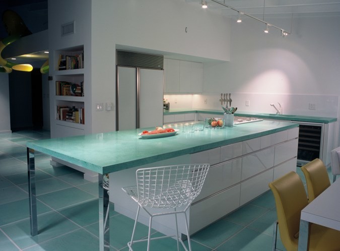 Inspiration for a medium sized contemporary u-shaped kitchen/diner in Miami with flat-panel cabinets, white cabinets, concrete worktops, white splashback, white appliances, an island and turquoise worktops.