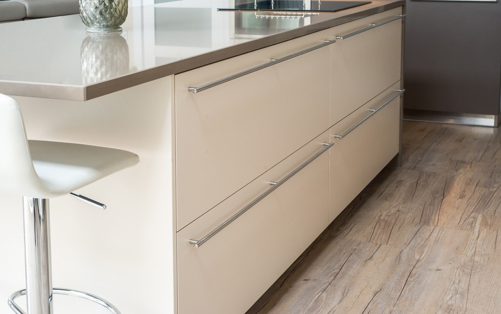 Immagine di una cucina design con lavello a doppia vasca, ante lisce, ante beige, top in quarzite e elettrodomestici in acciaio inossidabile