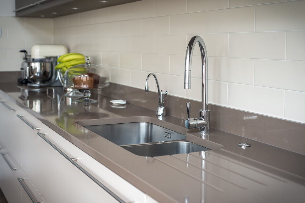 Esempio di una cucina contemporanea con lavello a doppia vasca, ante lisce, ante beige, top in quarzite e elettrodomestici in acciaio inossidabile