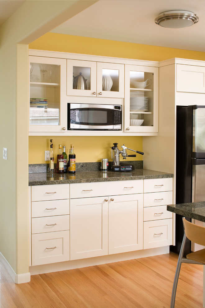 Foto de cocina contemporánea con electrodomésticos de acero inoxidable, puertas de armario blancas, encimera de granito y armarios estilo shaker