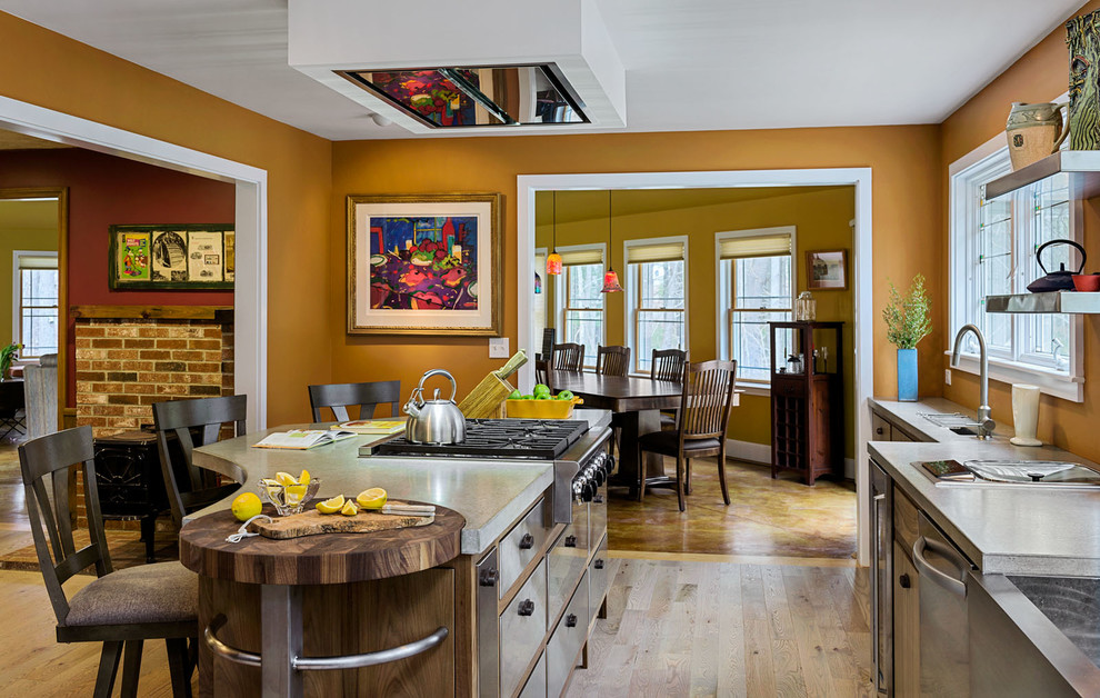 Mittelgroße Urige Küche in L-Form mit flächenbündigen Schrankfronten, Edelstahlfronten, Betonarbeitsplatte, Küchengeräten aus Edelstahl, hellem Holzboden und Kücheninsel in Portland Maine