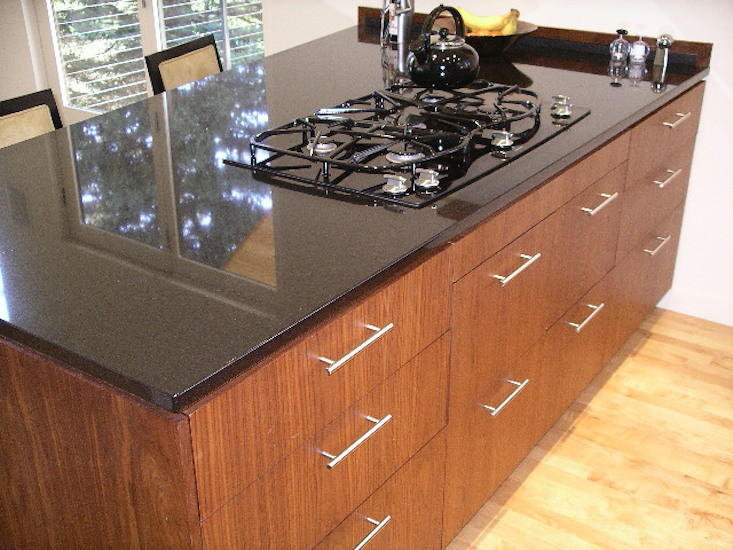 Exempel på ett mellanstort modernt kök, med en undermonterad diskho, släta luckor, bruna skåp, bänkskiva i onyx, flerfärgad stänkskydd, stänkskydd i keramik, svarta vitvaror, ljust trägolv, en köksö och brunt golv