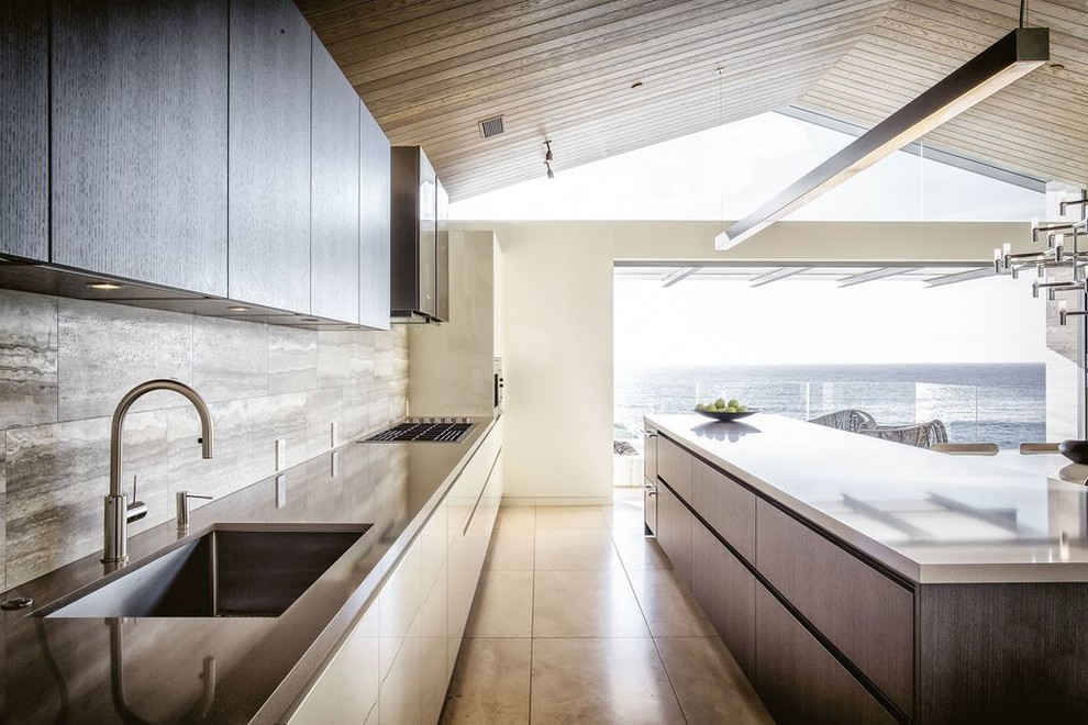 Inspiration for a medium sized modern galley open plan kitchen in San Francisco with a submerged sink, flat-panel cabinets, dark wood cabinets, zinc worktops, brown splashback, stone tiled splashback, stainless steel appliances, travertine flooring and an island.