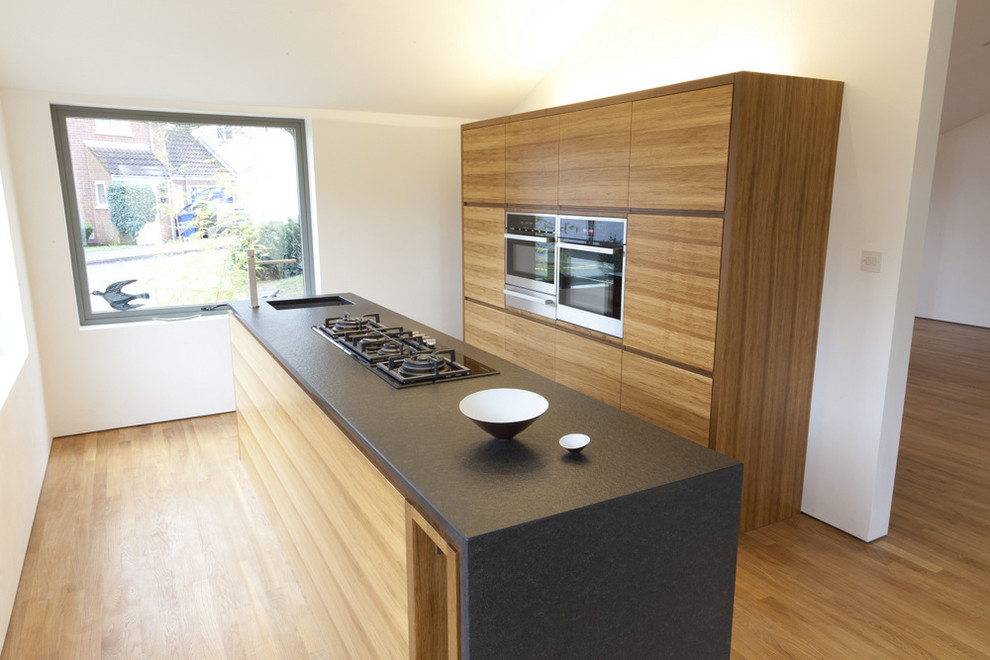 Geschlossene, Zweizeilige, Kleine Moderne Küche mit Unterbauwaschbecken, hellbraunen Holzschränken und Kücheninsel in London
