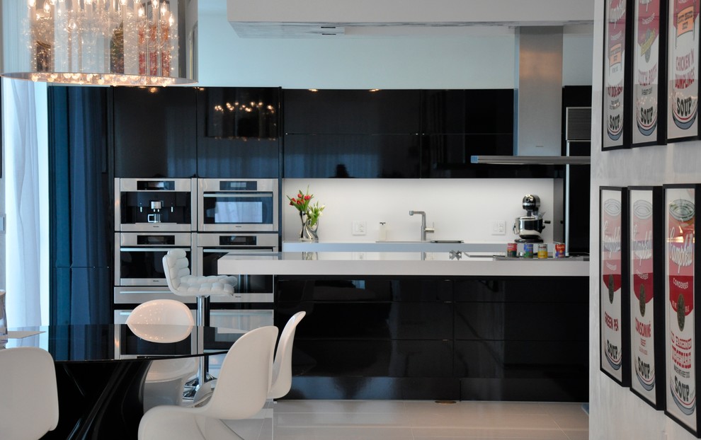 Esempio di una cucina moderna di medie dimensioni con lavello sottopiano, ante lisce, ante nere, top in quarzo composito, paraspruzzi bianco, paraspruzzi in lastra di pietra, elettrodomestici in acciaio inossidabile e pavimento in marmo