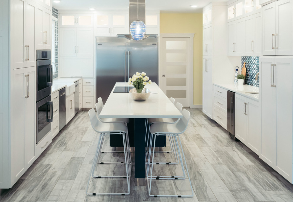 Exempel på ett stort modernt vit vitt kök, med en rustik diskho, skåp i shakerstil, gula skåp, bänkskiva i kvarts, blått stänkskydd, stänkskydd i glaskakel, rostfria vitvaror, klinkergolv i porslin, en köksö och grått golv