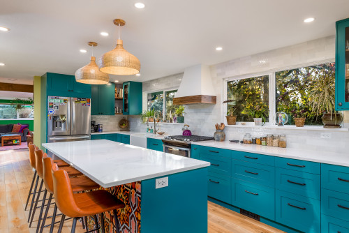 Modern kitchen featuring premium RTA cabinets Canada in bold teal shaker style with white quartz countertops and natural wood accents.