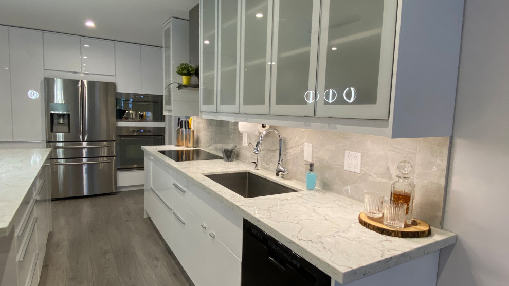 Modern inredning av ett mellanstort flerfärgad flerfärgat kök, med en undermonterad diskho, luckor med glaspanel, vita skåp, bänkskiva i kvarts, grått stänkskydd, stänkskydd i porslinskakel, rostfria vitvaror, laminatgolv, en köksö och grått golv
