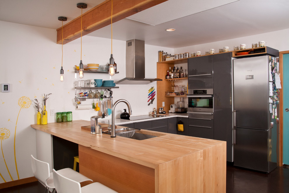 Small contemporary u-shaped kitchen in Seattle with a submerged sink, open cabinets, light wood cabinets, wood worktops, stainless steel appliances and a breakfast bar.