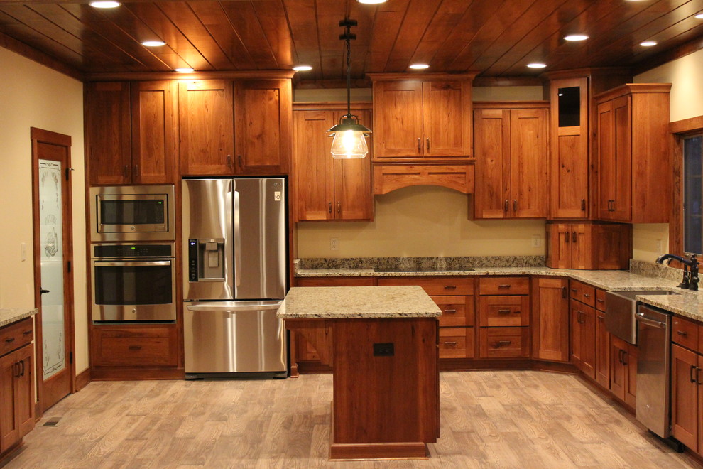Exempel på ett stort klassiskt kök, med en rustik diskho, skåp i mellenmörkt trä, granitbänkskiva, rostfria vitvaror, mellanmörkt trägolv och en köksö