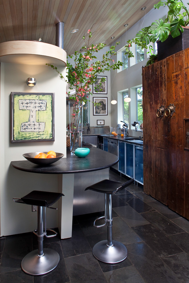Пример оригинального дизайна: кухня в современном стиле с обеденным столом и стеклянными фасадами