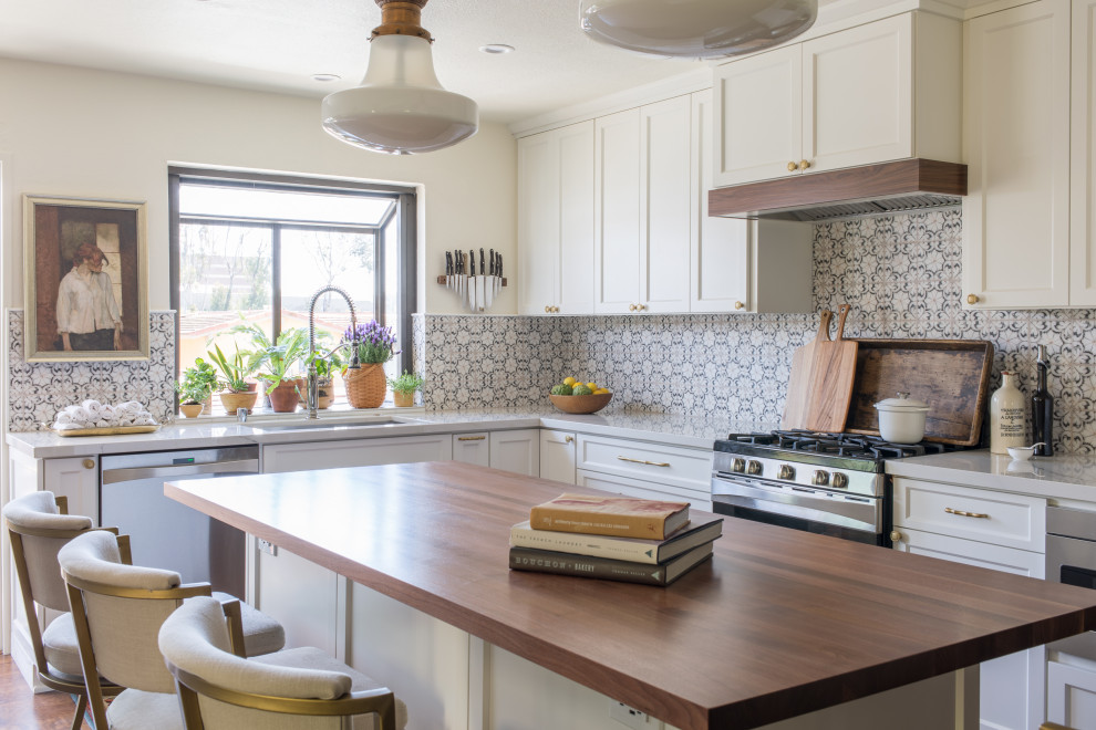 This is an example of a medium sized classic l-shaped kitchen/diner in San Diego with a built-in sink, shaker cabinets, white cabinets, wood worktops, white splashback, marble splashback, stainless steel appliances, medium hardwood flooring, an island, brown floors and brown worktops.