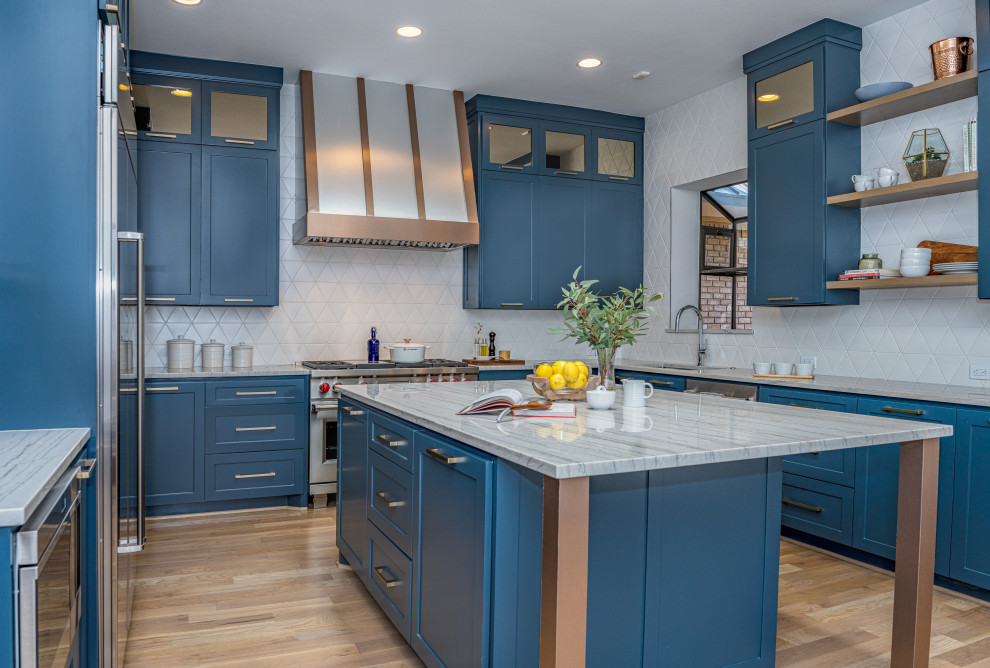 Foto di una cucina chic con lavello sottopiano, ante in stile shaker, ante blu, paraspruzzi bianco, elettrodomestici in acciaio inossidabile, pavimento in legno massello medio, pavimento marrone e top grigio
